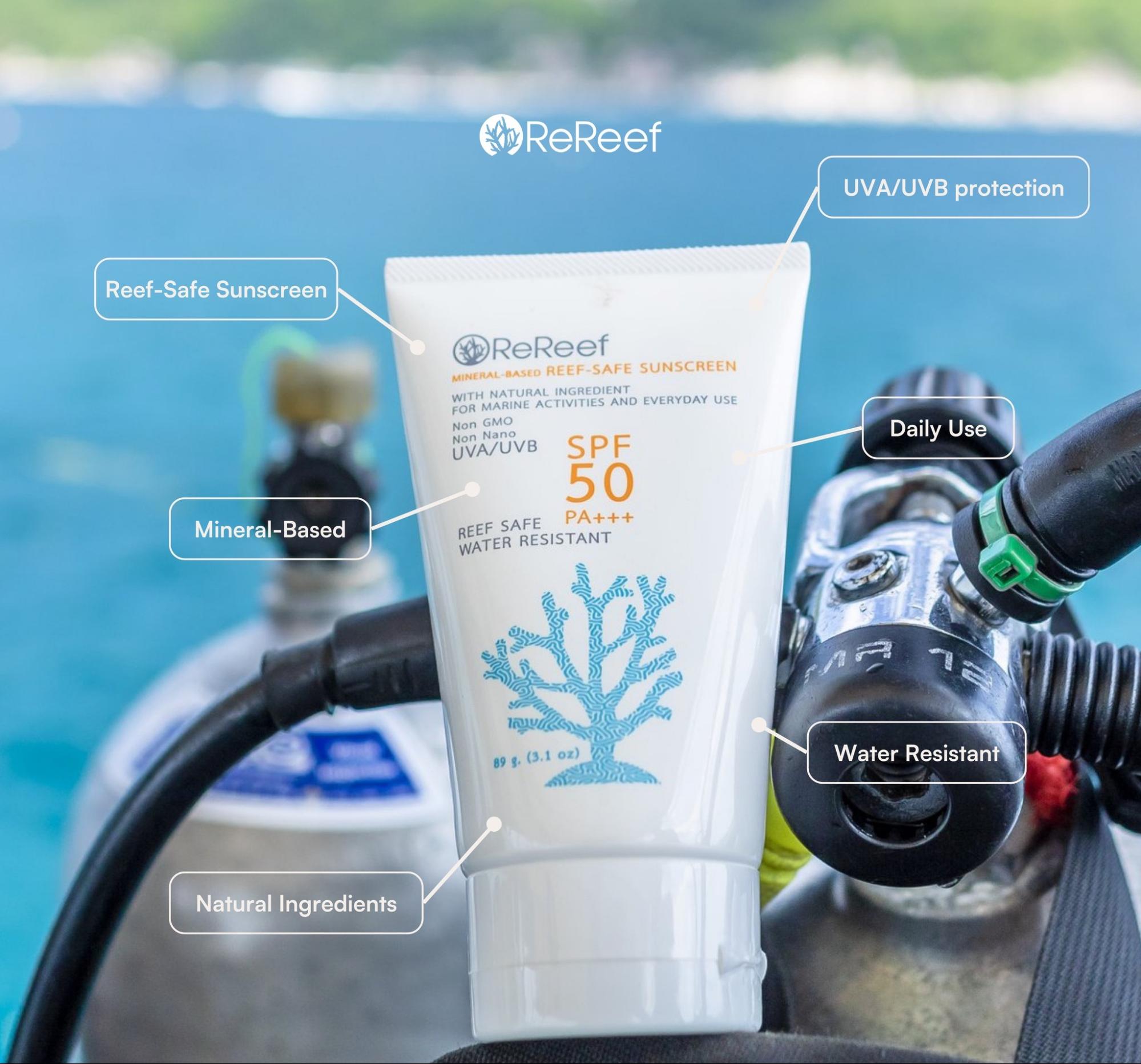 Reef-safe sunscreen tube placed with dive computer and regulator